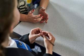A secondary school pupil sitting at a table with a Place2Be counsellor