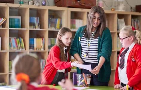 school counellor talking to young people in library