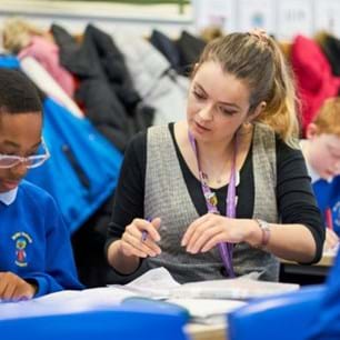 Place2Be school counsellor talking to child in classroom