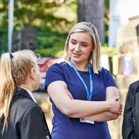 teacher standing with children talking