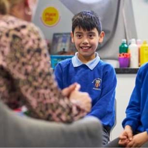 school counsellor talking to two primary school pupils in therapy room