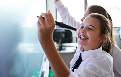 Girl writing on school whiteboard