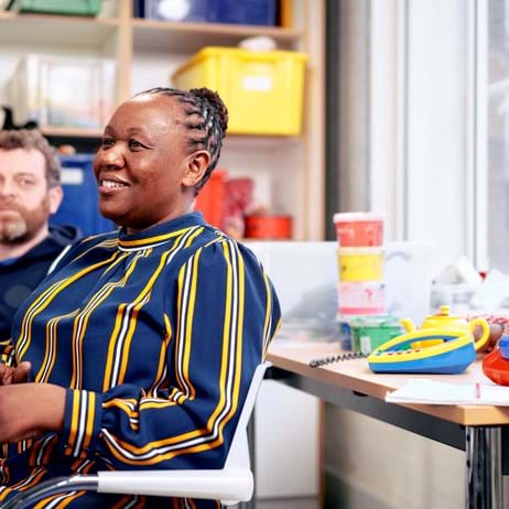 child counsellor training session with two people sat down at table in colourful training room