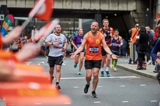 Place2Be runner dressed in an orange wig with arms in air